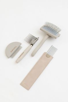 three different types of toothbrushes and combs on a white surface with a leather case