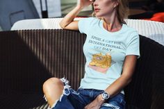 a woman sitting on top of a chair wearing a t - shirt that says sedula at the international cat day