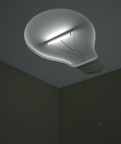 a white light bulb suspended from the ceiling in a room with dark walls and flooring