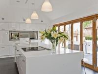 a large kitchen with an island in the middle and lots of windows on both sides