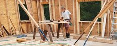 a man is working on the framing of a house