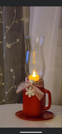 a red cup with a candle in it sitting on a table