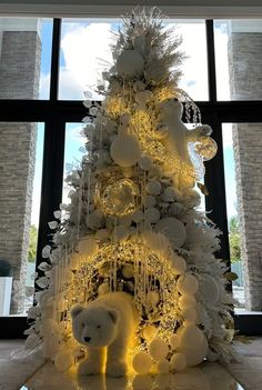 a white christmas tree decorated with lights and teddy bears