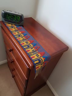 an alarm clock sitting on top of a wooden dresser