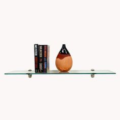 a shelf with two books and a vase sitting on it's side, against a white background