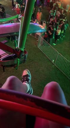 people are sitting in the grass at an outdoor music festival, with colorful lights on them