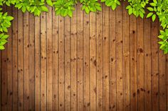 a wooden background with green leaves on it