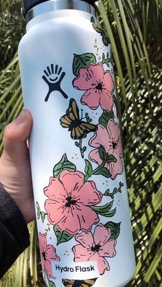 a hand holding a hydro flask with flowers on it