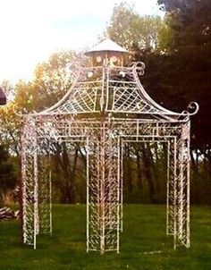 a white gazebo sitting on top of a lush green field