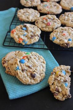 cookies with sprinkles and chocolate chips are cooling on a rack next to a blue towel