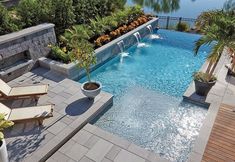 an outdoor swimming pool surrounded by trees and plants