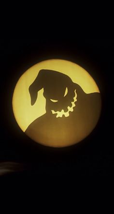 the silhouette of a dog is shown in front of a full moon with an evil face