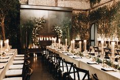 a long dining table with candles and flowers on the tables is set for an event