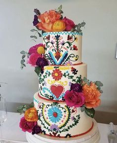 a multi - tiered cake decorated with colorful flowers