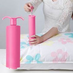 a woman sitting on a bed with a pink bottle and soap dispenser