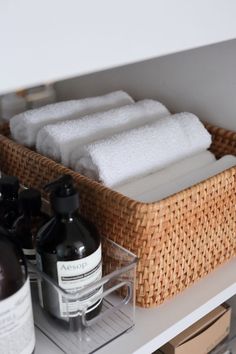 the bathroom shelf is organized with soaps and lotion in baskets on top of it