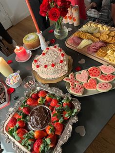 a table topped with lots of heart shaped cakes and desserts