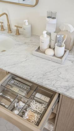 an open drawer in a bathroom next to a sink