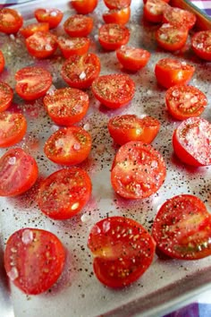 sliced tomatoes on a baking sheet ready to be cooked in the oven for roasting