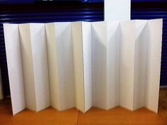 three tall white partitions sitting next to each other in front of a blue wall