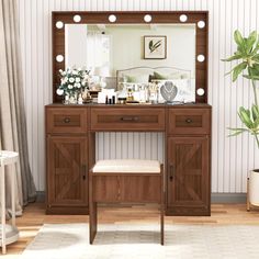 a wooden vanity with lights on it in front of a mirror and potted plant