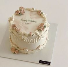 there is a white cake with pink flowers on it