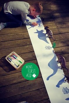 a young boy is making a paper cut out of the shape of a cat and other animals