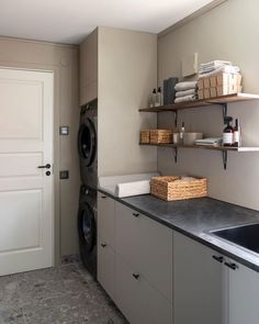 a washer and dryer in a room with shelves on the wall above them