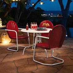 two red chairs and a white table with food on it