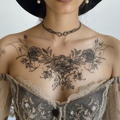 a woman with tattoos on her chest wearing a hat