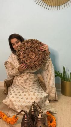 a woman sitting on the floor holding a decorative item