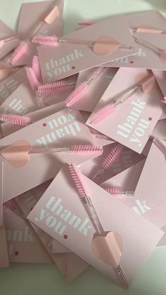 pink thank you notes with heart cutouts on them are laid out in a pile