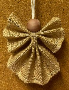 an ornament hanging from a rope on the wall with a wooden ball in it