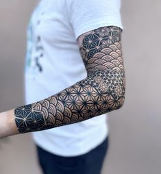 a man's arm with an intricate tattoo design on the arm and shoulder,