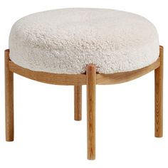 a wooden stool with a sheepskin seat cushion on it's backrest and legs