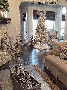 a living room filled with furniture and a christmas tree in the middle of the room