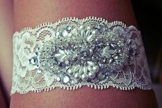 a white lace garter with pearls and beads on it