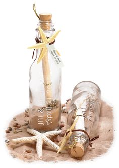 starfish in a bottle with sand and sea shells on the ground next to it