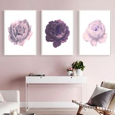 three paintings on the wall above a white table in a living room with pink walls