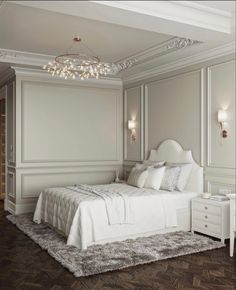 a white bed sitting in a bedroom on top of a hard wood floor next to a wall