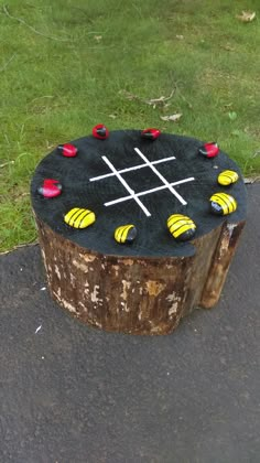 a tic - tac - toe board sitting on top of a tree stump