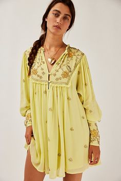 Made in Bali, this beautiful mini dress features allover bead and sequin embellishments. * Shapeless silhouette. * Plunging neckline with button closures * Raw trim * Hip pockets * Sheer long sleeves with a smocked elastic cuff * Lined | Bali Golden Sun Dress at Free People in Yellow, Size: XS Beautiful Mini Dresses, Golden Sun, Plunging Neckline, Sundress, Boho Outfits, Dress Shop, Free People, Bali, Fabric Design