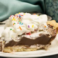 a piece of chocolate ice cream pie with sprinkles and cookies on the side