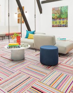 a living room filled with furniture and colorful rugs on top of carpeted flooring