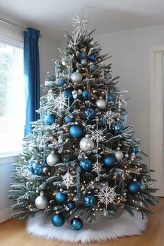 Blue and white Christmas Tree Green Tree With Blue Decorations, Snowflake Theme Tree, White Silver And Blue Christmas Decor, Fantasy Themed Christmas Tree, Snow Theme Christmas Tree, Winterwonder Land Christmas Tree, Xmas Tree Blue And Silver, White Silver And Blue Christmas Tree, Dining Room Decor For Christmas