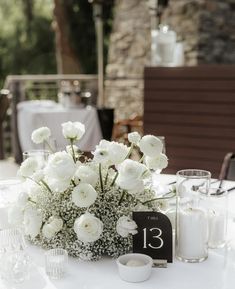 the table is set with white flowers and candles