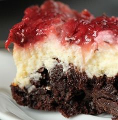 a close up of a piece of cake on a plate with strawberry topping and icing