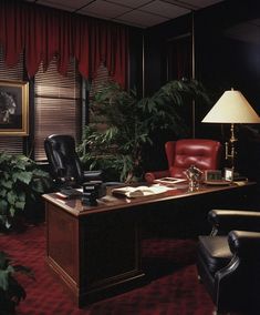 an office with red carpeting and black leather chairs in front of a wooden desk