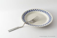 a fork in a blue and white plate with a chain