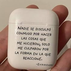 a hand holding an electronic device with spanish writing on it's side and in the palm of its left hand